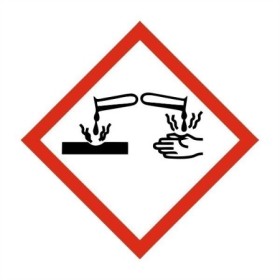 Corrosive hazard GHS symbol sign showing liquid damaging hand and surface