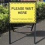 Please Wait Here high-visibility sign